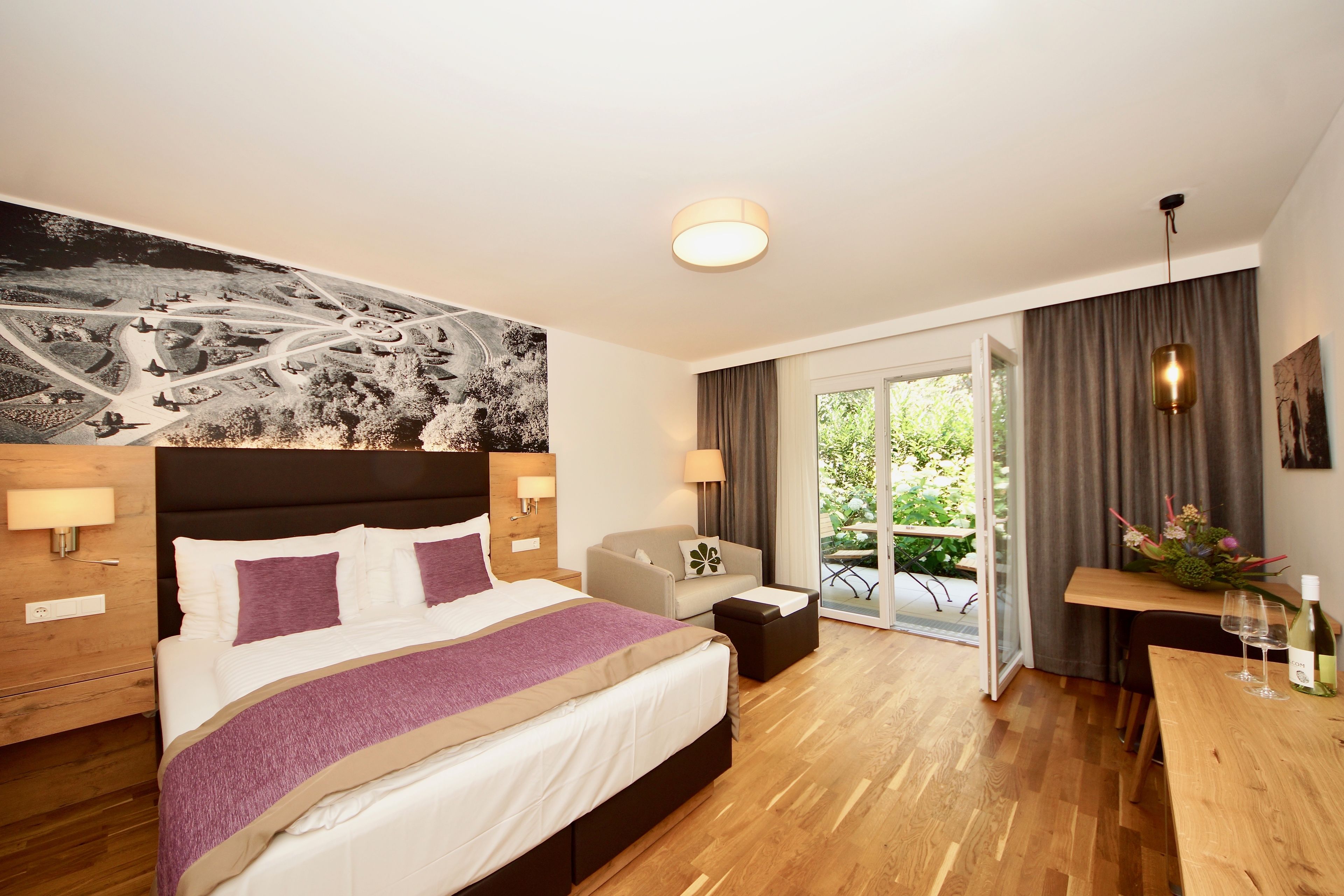 Una habitación de hotel moderna con una cama grande, un sofá, una mesa de comedor y un balc ón con vistas.