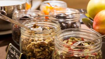 A variety of food items in glass jars, including nuts and dried fruits, with a sign indicating 'Fruits & Nuts - Dried Fruits'.