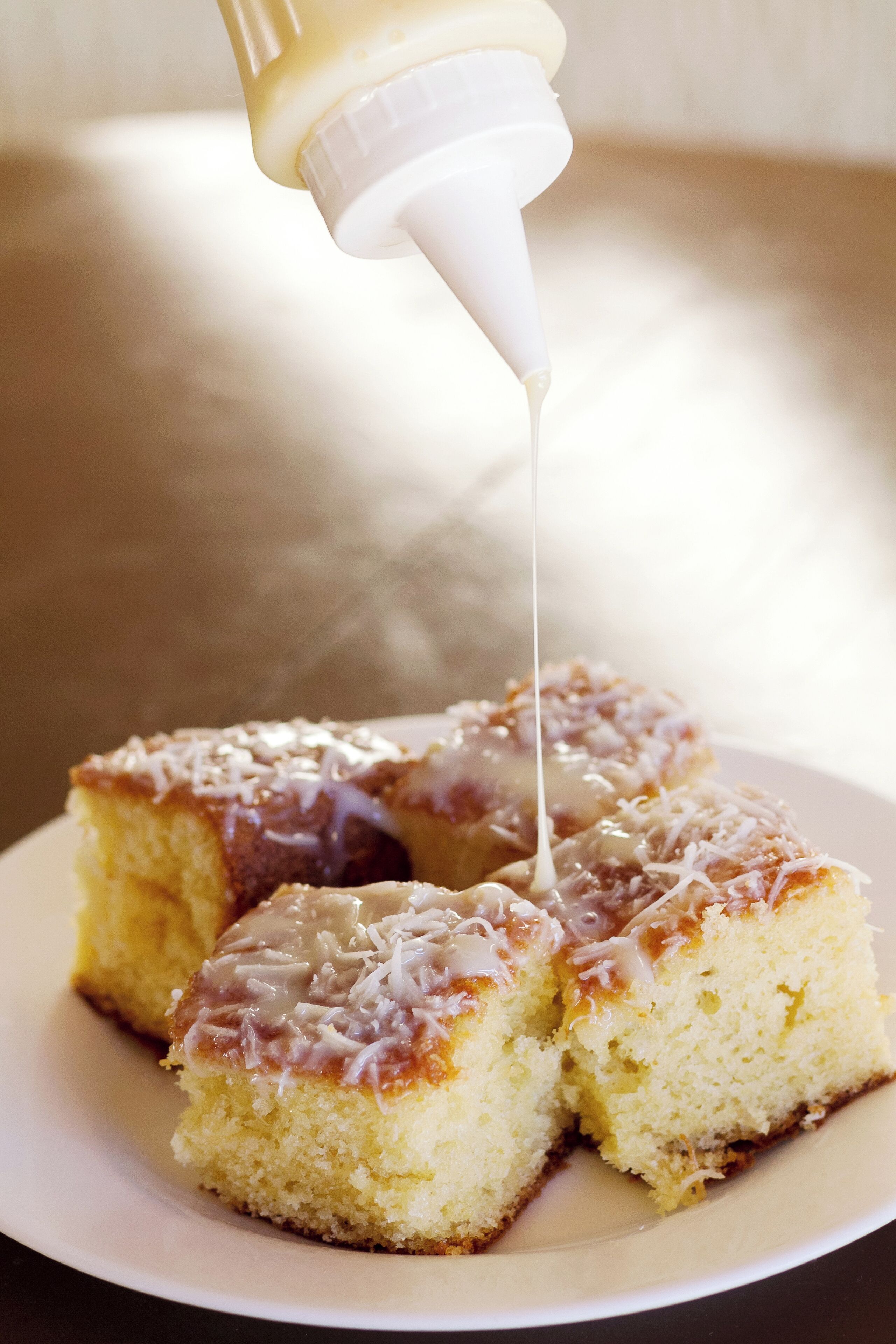 Un pastel con glaseado blanco que se está sirviendo.
