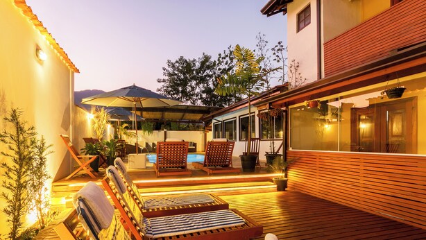 A wooden deck with lounge chairs and a pool area. - Pousada Recanto do Jabaquara (Paraty)