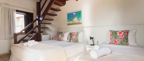 A hotel room with two beds, a wooden staircase, and a painting on the wall.