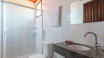 Un baño con inodoro, lavabo y ducha.