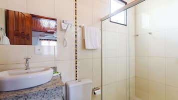 Une salle de bain équipée d’un lavabo, de toilettes et d’une douche à parois de verre.