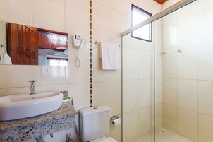 Een badkamer met een wastafel, toilet en een douchecabine.