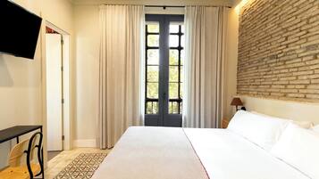 Deluxe Room with Balcony or Patio | Ropa de cama de alta calidad y edredones de plumas