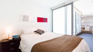 Une chambre d’hôtel avec un grand lit, un bureau et une vue sur la ville.