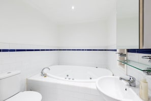 Un baño moderno con una bañera independiente, un inodoro y un lavabo.