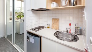Una cocina moderna con lavavajillas integrado, un fregadero con escurridor y una tabla de cortar de madera.
