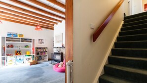 A staircase leading to a landing with a bookshelf and a pink bean bag chair. - KELLY, 3BDR Northcote House (Northcote)