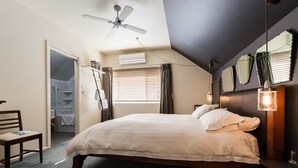A bedroom with a bed, a ceiling fan, a window with curtains, a bedside table with a lamp, and a mirror on the wall. - KELLY, 3BDR Northcote House (Northcote)