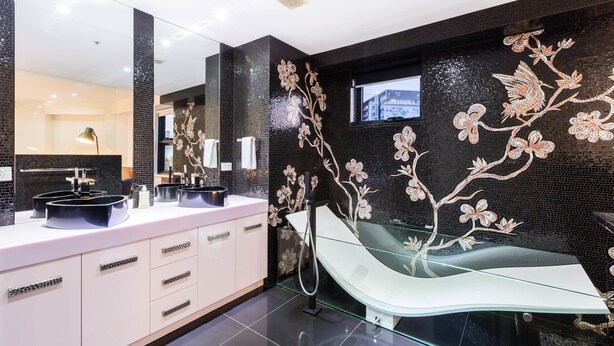 A modern bathroom with a black tiled wall, a glass shower enclosure, and a white vanity with a mirror. - MADDISON, 3BDR Port Melbourne Apartment (Port Melbourne)