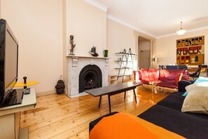 Cozy living room with a fireplace, comfortable sofa, and modern coffee table.