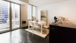 Una cocina moderna con encimera negra, armarios blancos y un amplio ventanal con vistas a la ciudad.