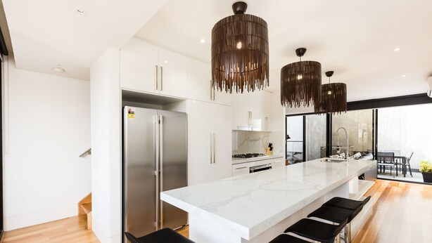 A modern kitchen with a large island, stainless steel appliances, and pendant lighting. - RENEE, 4BDR North Melbourne House (North Melbourne)
