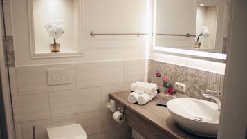 Ein modernes Badezimmer mit Toilette, Waschbecken und Spiegel.