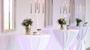 A row of tables with white drapes and candles, set against a wall with arched mirrors. - Trautwein - Das Winzerhotel am La Roche (Flonheim)