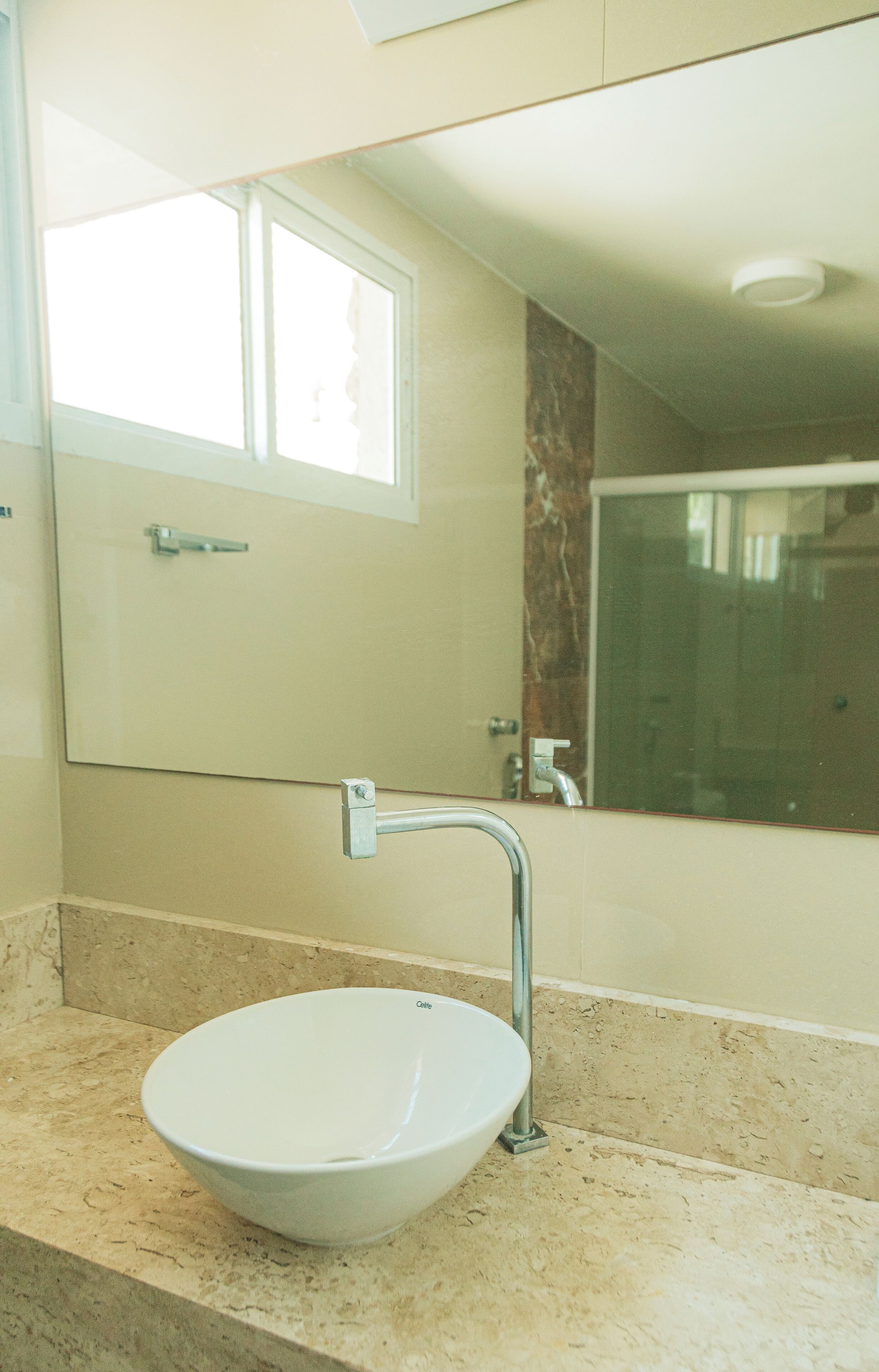 A bathroom with a white sink, a mirror, and a shower.