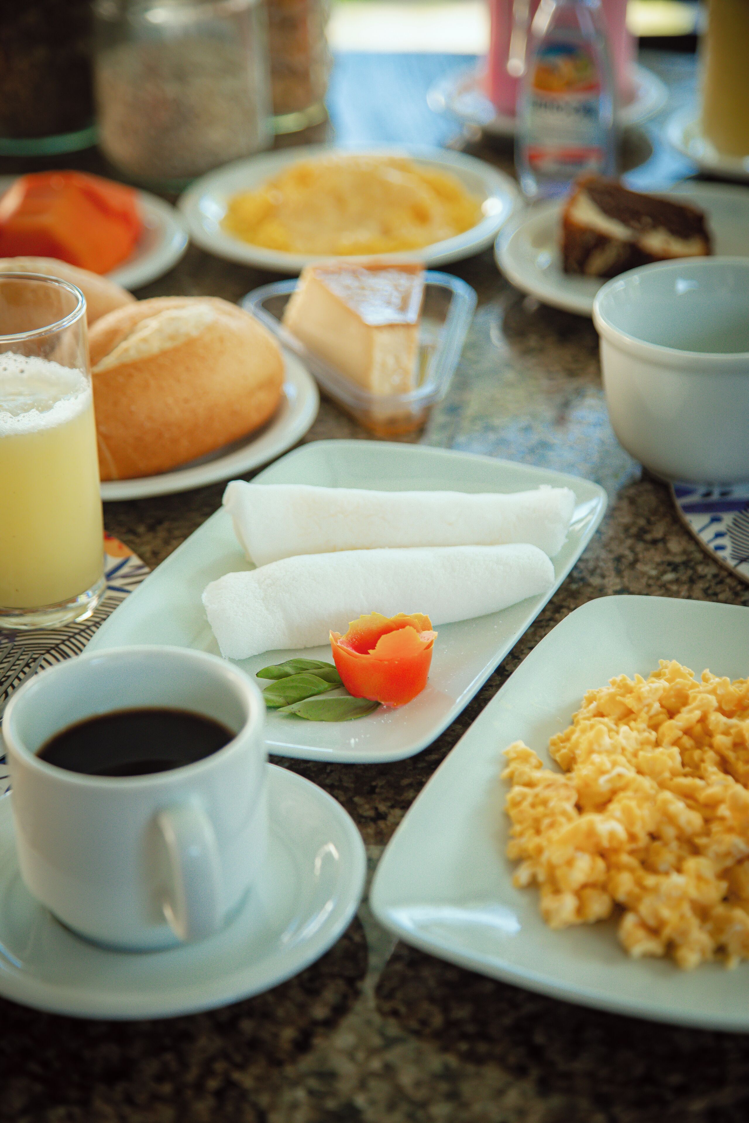 Una tavola imbandita per la colazione, con diverse pietanze tra cui uova, pane e una tazza di caffè.