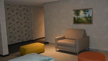 A living room with a beige armchair, a yellow ottoman, and an orange ottoman.