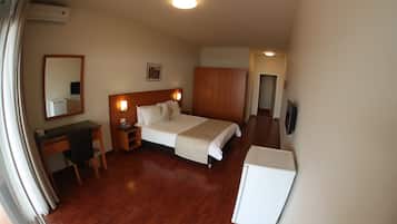 Ein Hotelzimmer mit einem Bett, einem Schreibtisch, einem Kleiderschrank und einem Fernseher.