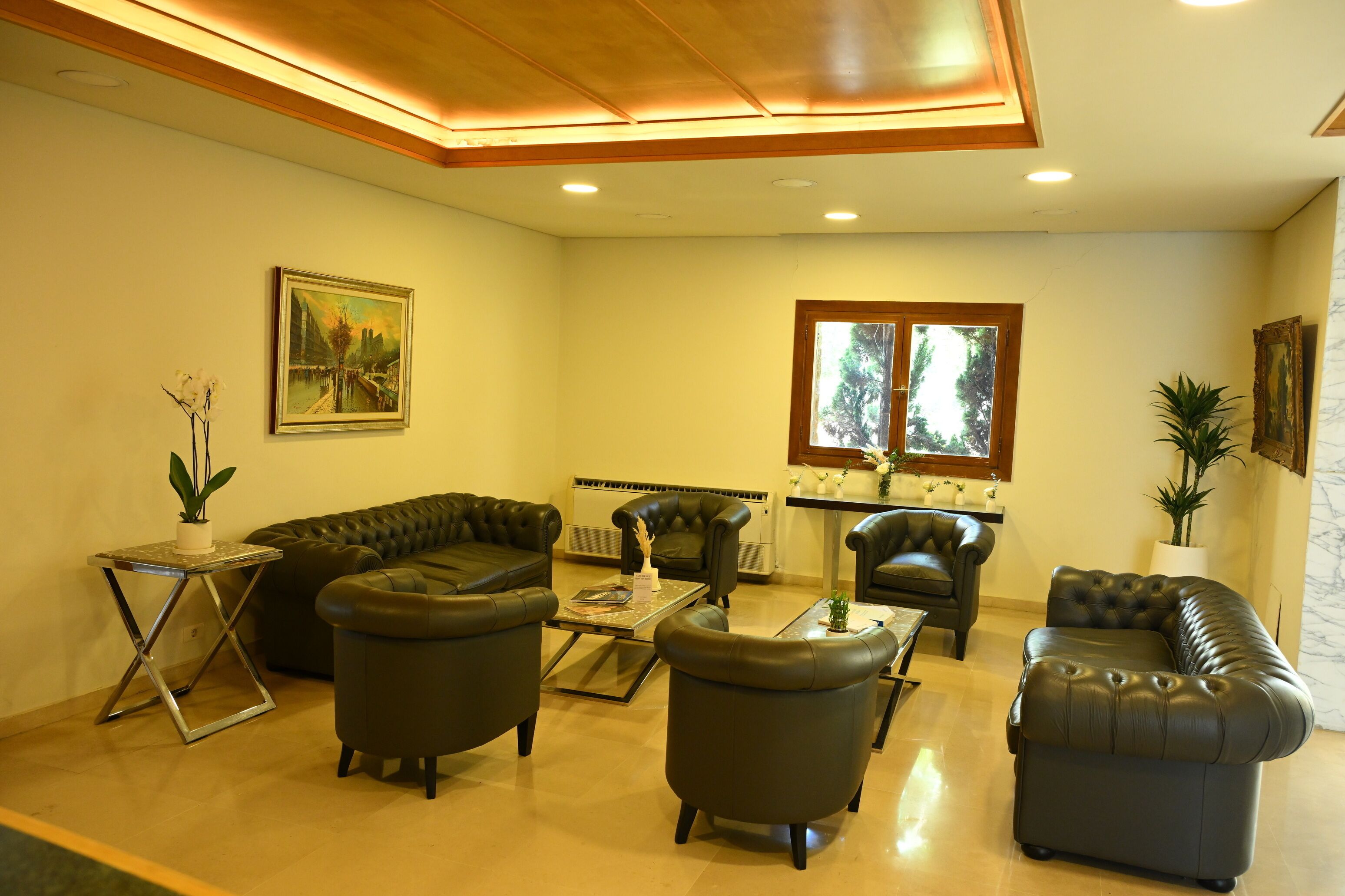A living room with a sectional sofa, two armchairs, a coffee table, and a fireplace.