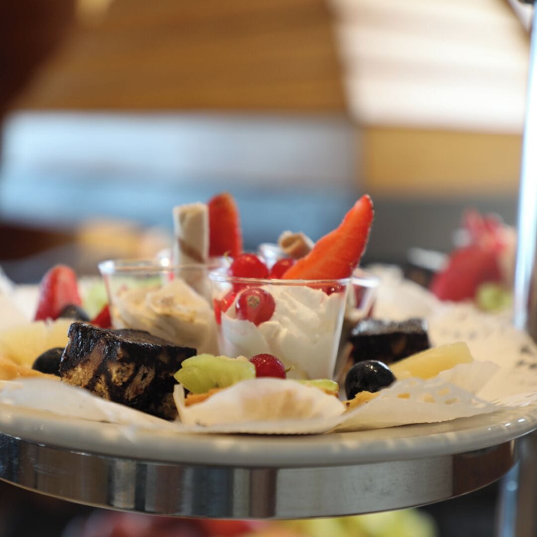 Een presentatiebord met diverse soorten fruit en een taart.