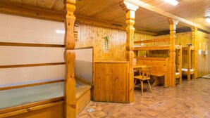Un intérieur en bois, avec un sol carrelé, des bancs en bois et un radiateur fixé au mur.