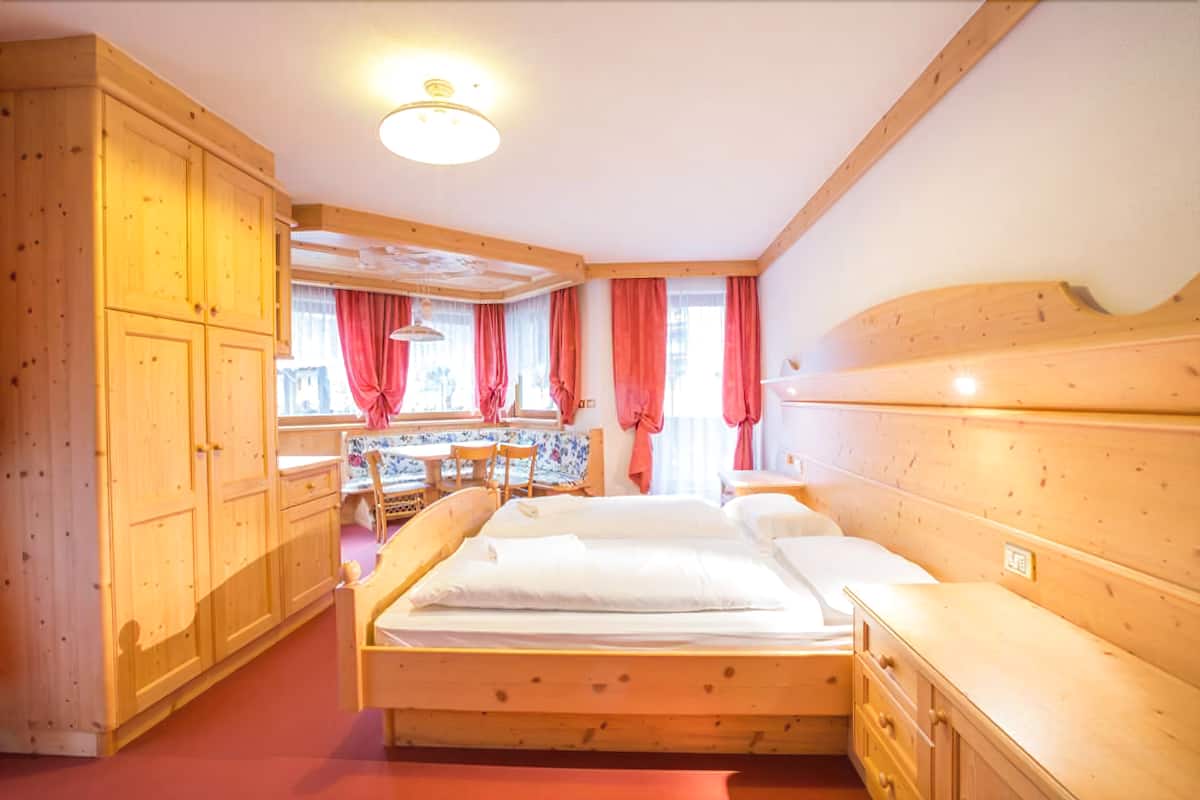 Une pièce en bois avec un lit, une table et une chaise.