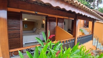 Quarto de hotel com uma cama, uma janela e uma varanda com guarda-corrimão.