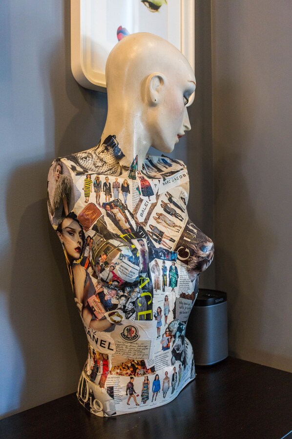 Un busto de maniquí cubierto de recortes de revistas y publicidad.