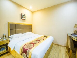 A hotel room with a bed, a nightstand, a desk, and a lamp. - Greentree Inn Jiangsu Nantong Huida Square Yuejian (Nantong)