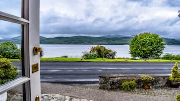 A view from a door to a lake with a stone bench, a bike, and a sign that reads "PUSH".