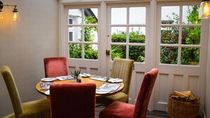 Un coin repas avec une table ronde, quatre chaises et un panier de pain.