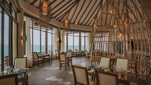 A dining area with tables, chairs, and hanging light fixtures. - Palafitos Overwater Bungalows, All & More Inclusive - Adults Only - All inclusive (Playa del Carmen)