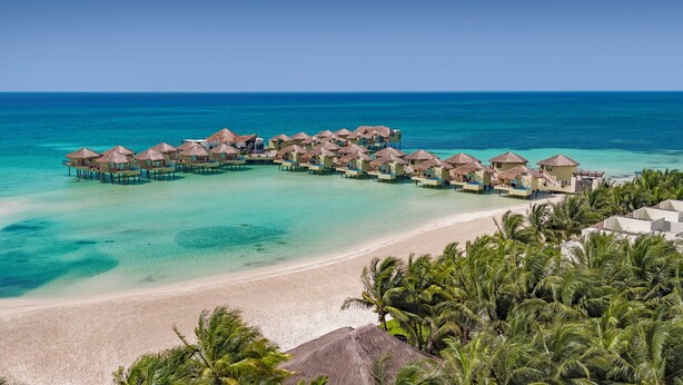 Overwater bungalows with thatched roofs, a sandy beach, and clear turquoise waters. - Palafitos Overwater Bungalows, All & More Inclusive - Adults Only - All inclusive (Playa del Carmen)