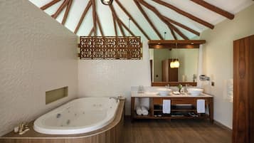 Un baño con una bañera independiente, un tocador doble y un espejo grande.