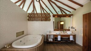 A bathroom with a freestanding bathtub, a vanity with two sinks, and a large mirror.