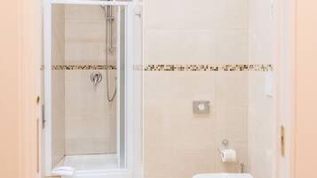 A bathroom with a shower, toilet, and sink.
