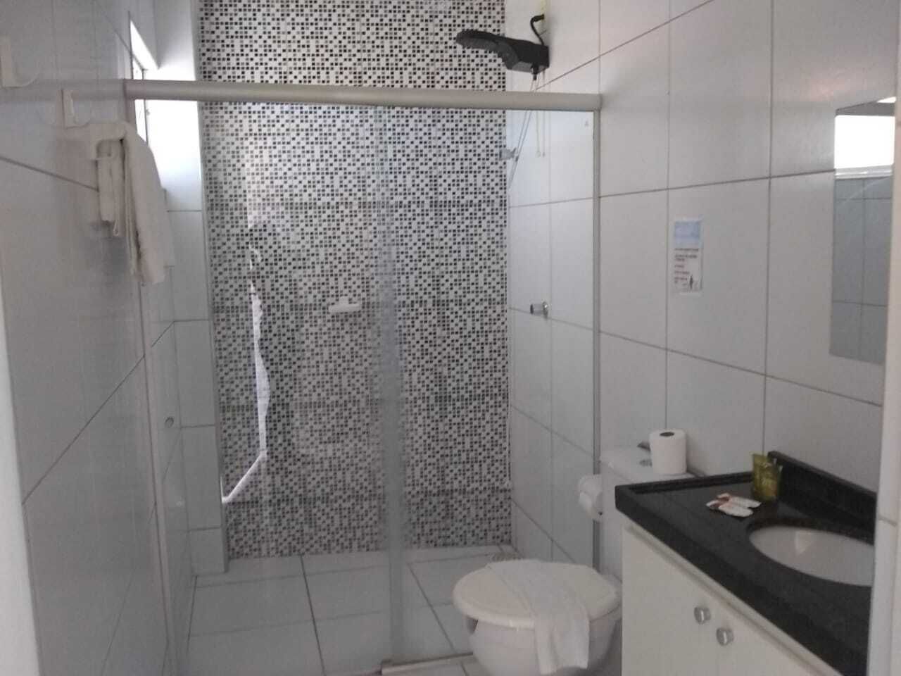 A bathroom with a shower, toilet, and sink.