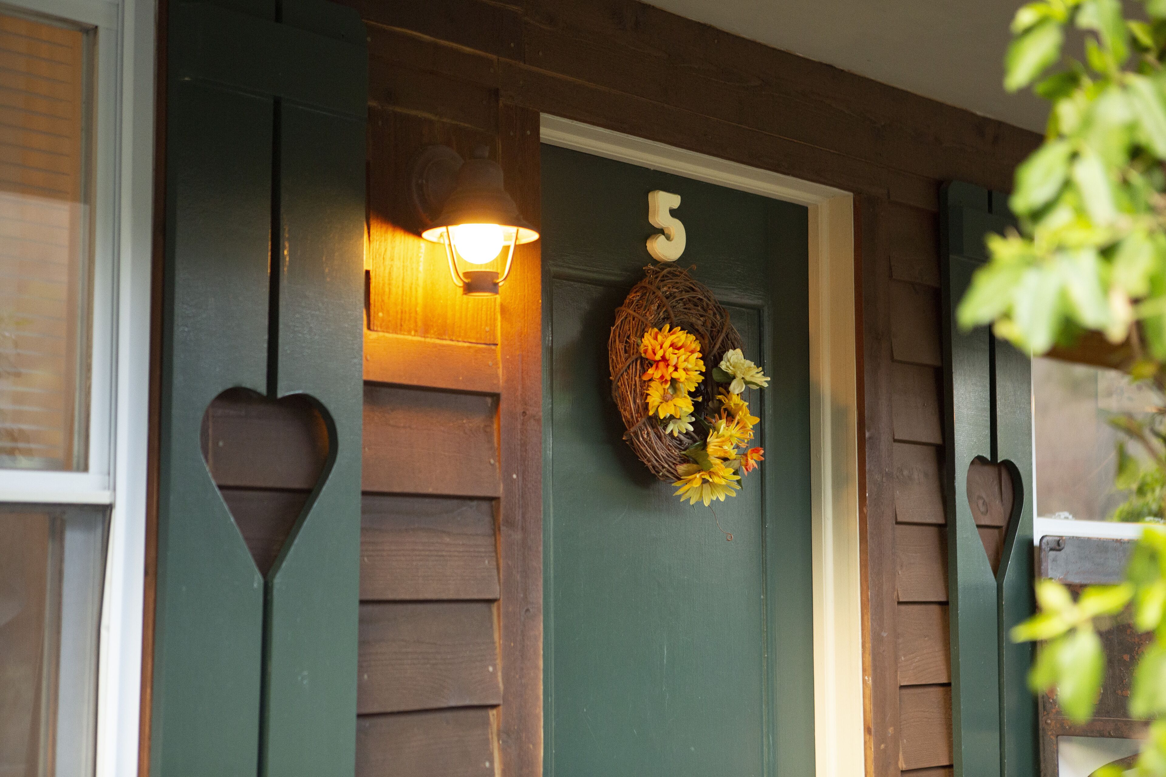 A wooden door with a number '5' and a decorative wreath with flowers.