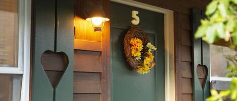 A wooden door with a number '5' and a decorative wreath with flowers.