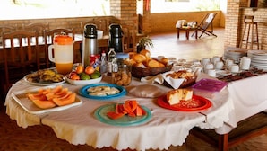 A breakfast buffet with various food items and beverages on a table. - Pousada Oceania (São Gonçalo do Amarante)