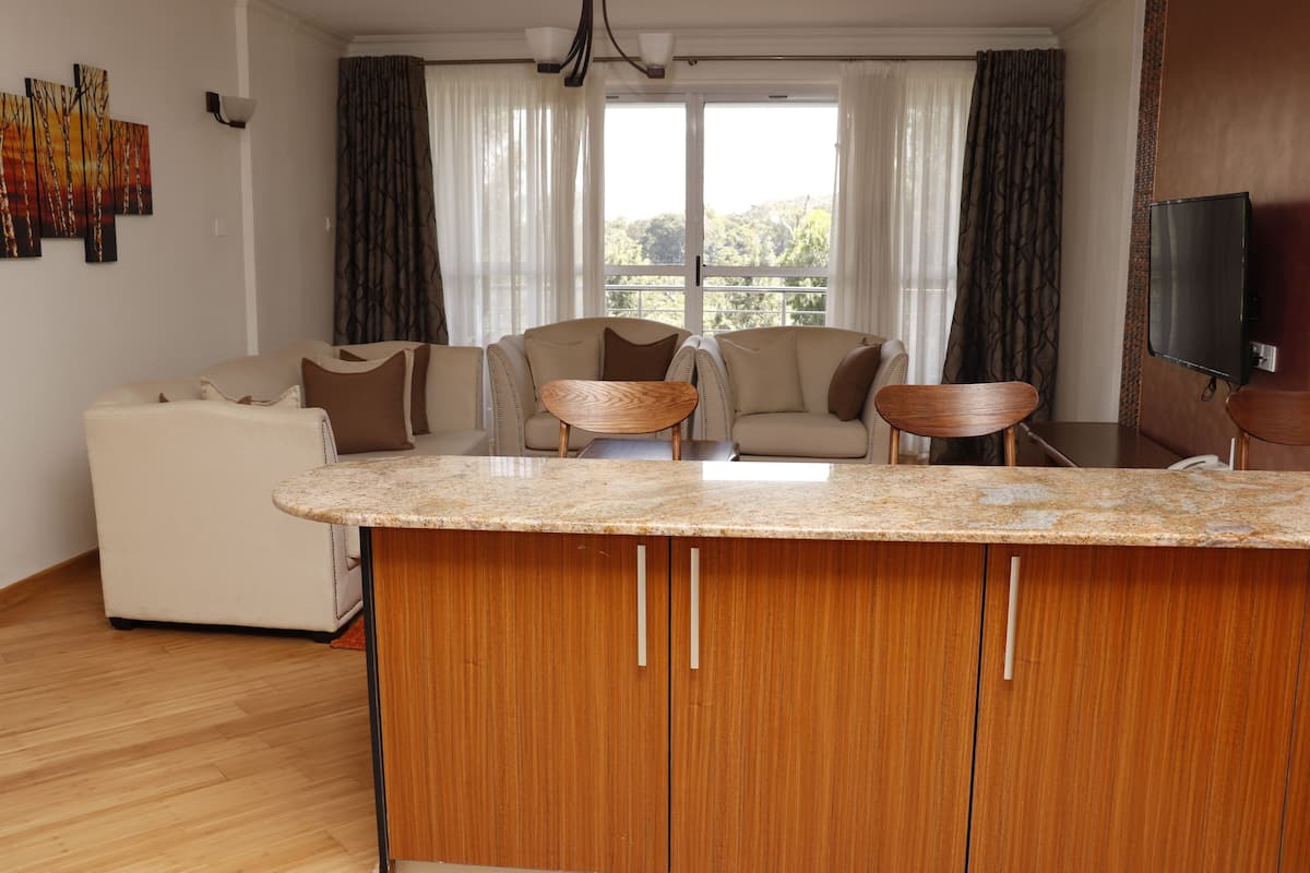 A modern living room with a wooden cabinet and a small round table, a sofa, and a chair.