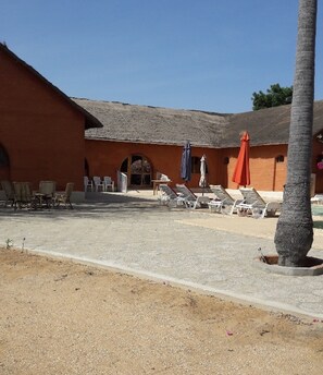 Een buitenzwembad en ligstoelen