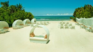 A beach setting with circular seating areas and a clear view of the ocean. - Bel Air Collection Resort & Spa Riviera Maya - All Inclusive (Xpu-Ha)
