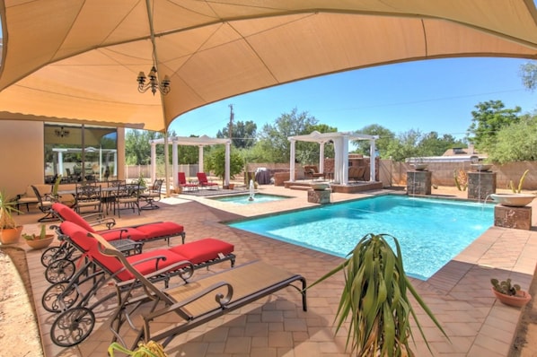 An outdoor pool area with lounge chairs, a pergola, and a covered seating area. - Hayden Manor (Scottsdale)