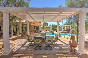 A covered outdoor area with a pool, seating, and a pergola structure. - Hayden Manor (Scottsdale)