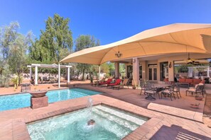 A pool area with a hot tub, lounge chairs, and a covered patio. - Hayden Manor (Scottsdale)