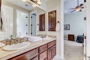 A bathroom with two sinks, a large mirror, and wooden cabinets. - Hayden Manor (Scottsdale)