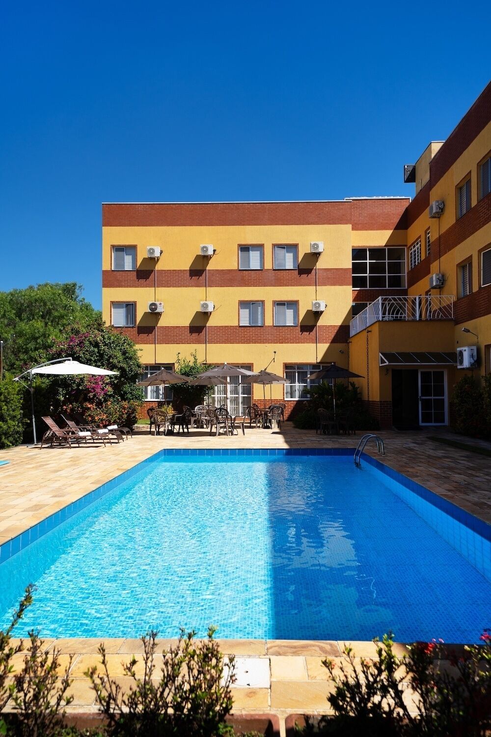 Una piscina al aire libre, sombrillas, tumbonas